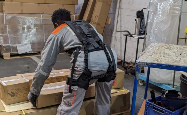Medarbejder paa lager med exoskelet fra Bisko